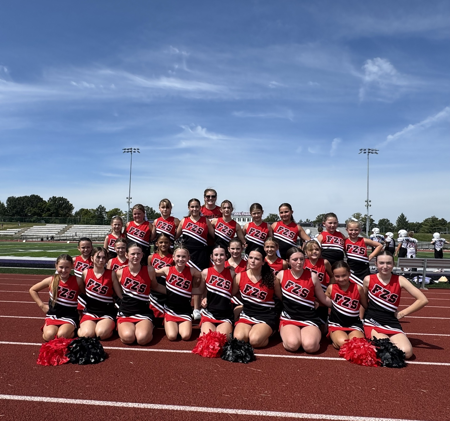 Junior Bulldogs cheerleaders gathered together on the track